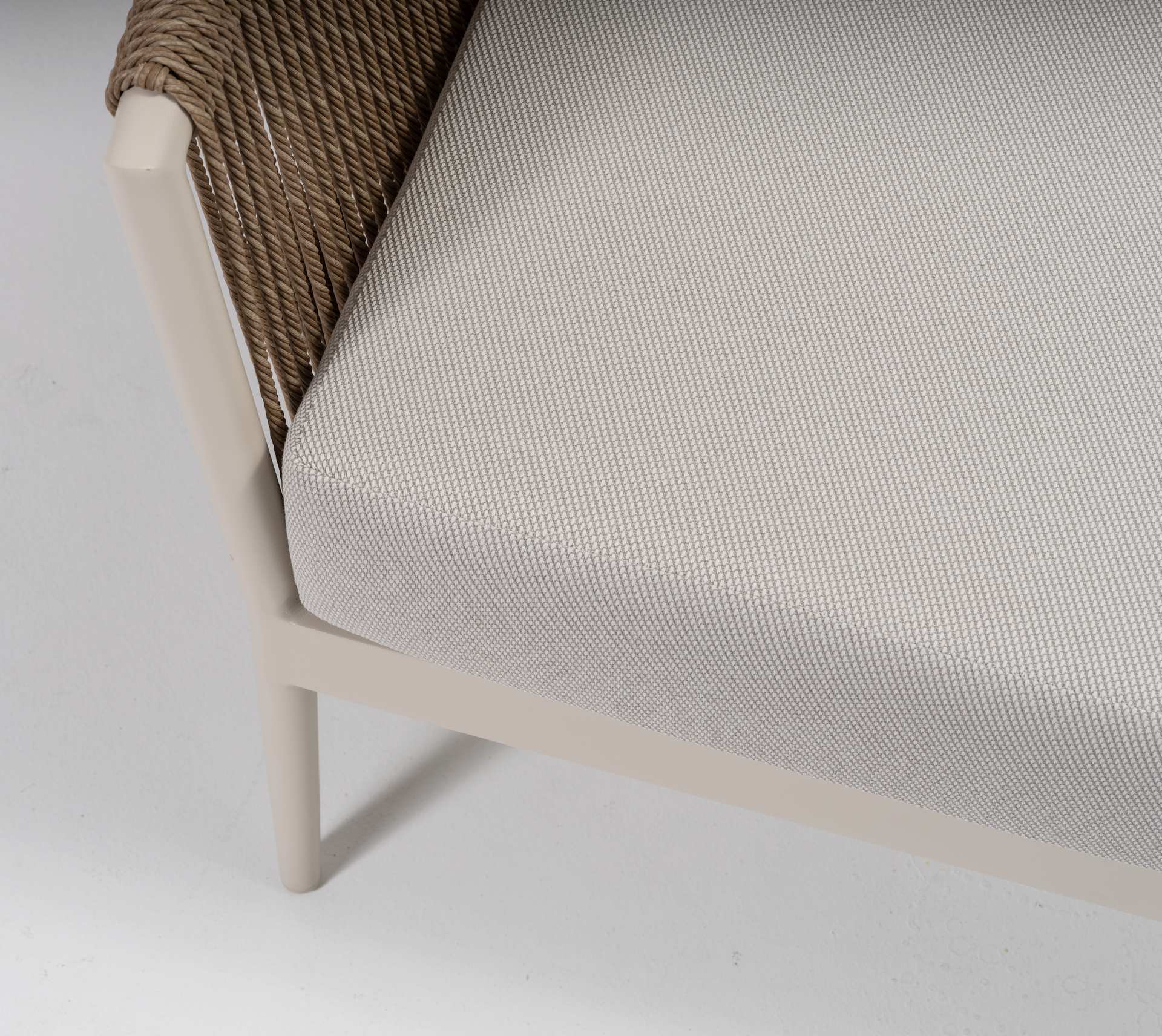 Loungegruppe Cassidy mit Aluminiumgestell in Ivory, sandfarbenen Textilschnüren, hellen Polstern und zwei Couchtischen.