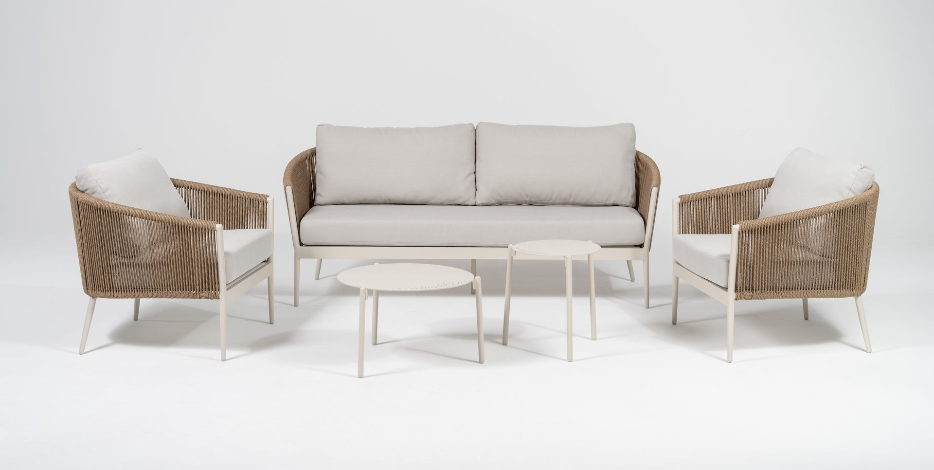 Loungegruppe Cassidy mit Aluminiumgestell in Ivory, sandfarbenen Textilschnüren, hellen Polstern und zwei Couchtischen.