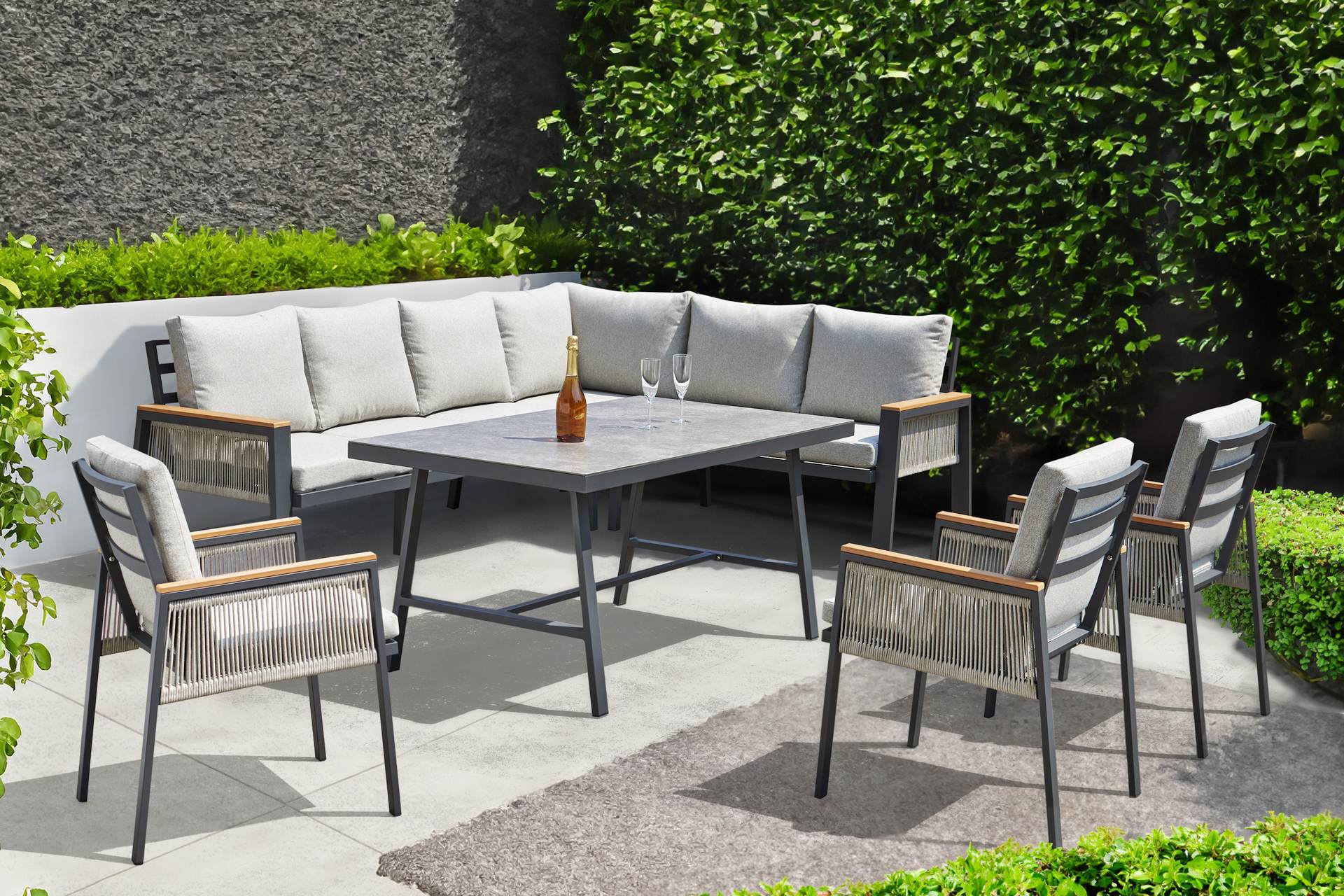 Chiara Eckbankgruppe mit anthrazitfarbenem Aluminiumgestell und Polywood-Armstützen in Teak-Optik, beige Textilschnüre und hellgraue Kissen, inklusive Tisch, bei Gartenmoebelshop.at verfügbar