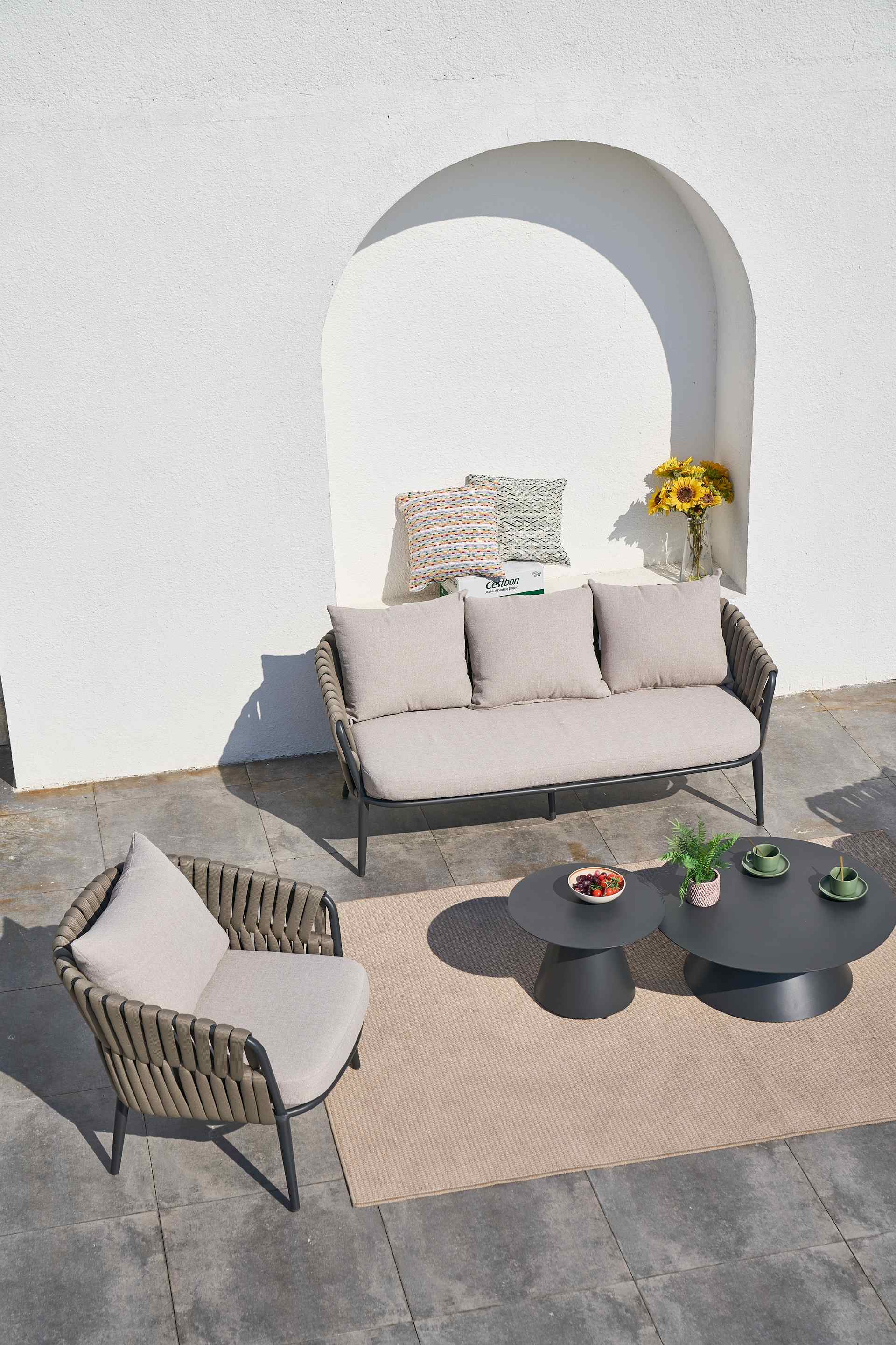 Loungegruppe Nero mit anthrazitfarbenem Aluminiumgestell, braunen Textilbändern und grauen Kissen. Moderne Outdoor-Lounge mit Couchtischen.